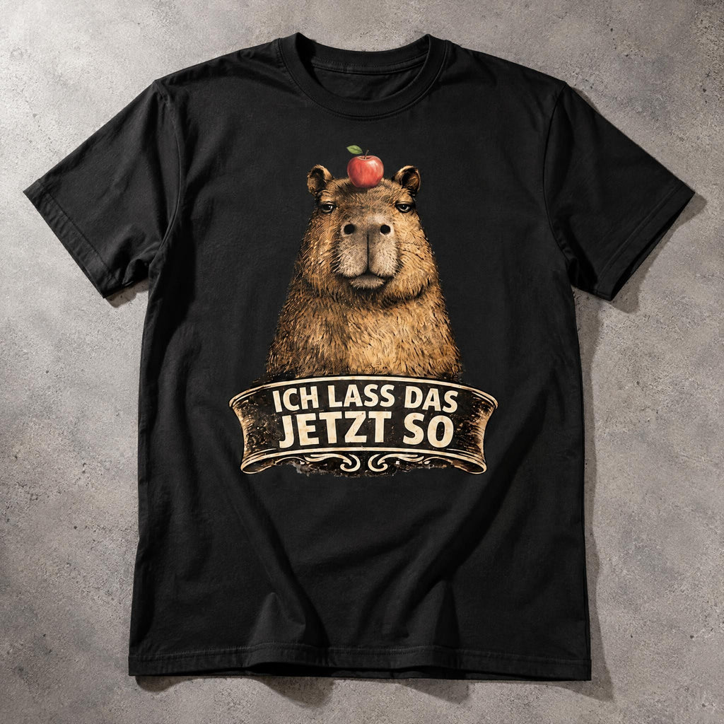 Black cotton t-shirt featuring a capybara graphic with an apple on its head and the slogan Ich lass das jetzt so.